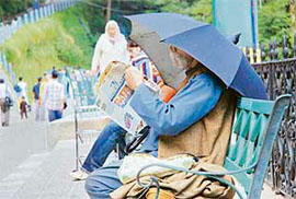 An old man engrossed in reading a newspaper near Lakkar Bazar in Shimla on Wednesday.