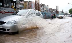 Vehicles move through waterlogged Vikas Marg.