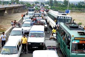 Journalists block traffic on the Tawi bridge leading to a massive jam on the Jammu-Srinagar highway