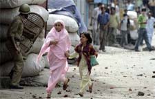 RUNNING FOR COVER: A Kashmiri woman and a girl run to save themselves from stones being thrown by protesters during a protest in Srinagar on Friday.