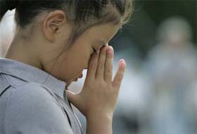 A girl prays for the atomic bombing victims at the Peace Memorial Park in Hiroshima, Japan