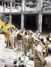The police seizes construction material and equipment from the parking site at the McLeodganj bus stand on Monday.