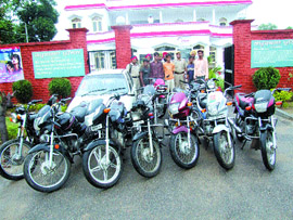 Arrested members of the gang in police custody along with the stolen vehicles.