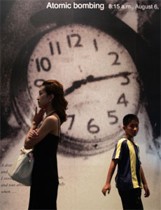 People walk past a photograph showing the time of the 1945 bombing at the Hiroshima Peace Memorial Museum, Japan, on Monday.