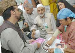 All-Party Hurriyat Conference chief Mirwaiz Umar Farooq  talks to the mother of a disappeared boy during a dharna against violation of human rights in J&K in Srinagar