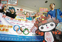 Local confederation of trade unions activists hold up a banner and a placard of the Beijing 2008 Olymics mascots "Fuwa", demanding the respect of labour rights in Chinese factories during a protest in Hong Kong on Wednesday.