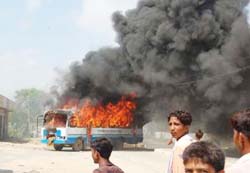 A Haryana Roadways burns after it was set afire at Barwala