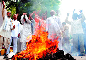 Activists of Loktantrik Samajwadi Party burn an effigy of UP Chief Minister Mayawati to protest against the proposed contract farming and amendment to the Mandis Act at Jantar Mantar in the Capital on Saturday.