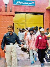 Indian fishermen follow a policeman after being released from a jail in Karachi