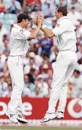 Englands Chris Tremlett (right) and James Anderson celebrate the dismissal of Dinesh Karthik on the fourth day of the third Test at the Oval on Sunday. 