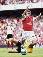 Arsenals Robin van Persie gets past Fulhams Moritz Volz during their English Premier League soccer match at the Emirates Stadium in London on Sunday. Arsenal won 2-1