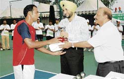 Pakistans Aqeel Khan receives the trophy from G.S. Bhullar (centre), SSP, Ludhiana (Rural), after winning the ITF Futures tennis title at Jassowal village, near Mandi Ahmedgarh, on Saturday.