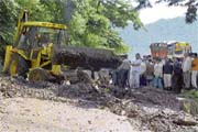 a JCB machine clears debris on the Parwanoo-Dharampur highway