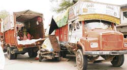 A three-wheeler is seen sandwiched between two trucks at Kup Da Tota Chowk near Ahmedgarh on Sunday.