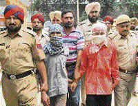 Two ULFA militants with Punjab police personnel in Jalandhar on Monday.