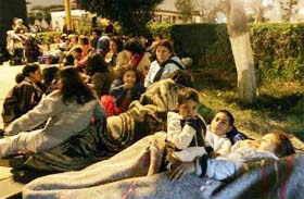People prepare to spend the night outside their homes in Lima's port of Callao after a powerful earthquake struck Peru