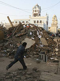 A man runs down a destroyed street in Pisco, 245 km south of Lima, on Friday. Peruvian rescue teams scrambled to find survivors in the disaster zone of a powerful earthquake where an aftershock of 6.0 magnitude struck. 