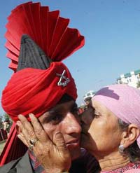 A mother kisses her son after the Jammu and Kashmir Light Infantry passing-out parade at a military base on the outskirts of Srinagar