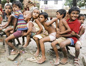 Children play as their parents queue up for relief at a centre at Maghbazar in Dhaka on Friday.