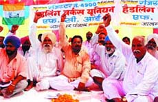 Members of FCI employees unions hold a protest in Jalandhar on Monday.