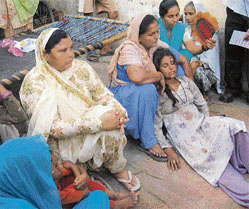 The dazed mother (reclinging) who lost three children to her husbands rage at Bakaralwa village in Kangra district on Tuesday.