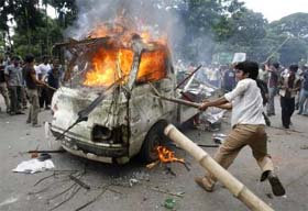 Angry students burn a vehicle during a clash at Dhaka University