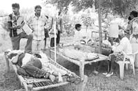 Patients lie in the open due to lack of space in the Primary Health Centre, near Ambala, on Thursday.