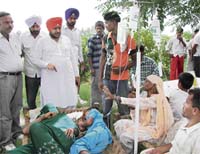 Harpal Singh Kamboj, Ambala district president of INLD, interacts with suspected gastroenteritis patients at Nurpur village in Ambala on Friday. 