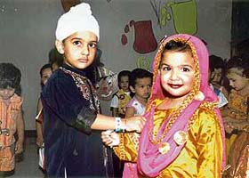 A student of Maple Bear School ties rakhi on her classmate’s wrist