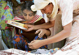 Sarabjit Kaur, sister of the deceased, ties rakhi on the hand of the charred Gurjeet Singh in Bathinda on Monday.