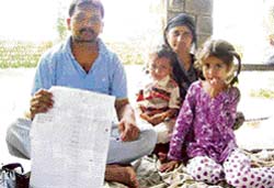 A Dalit family sitting on fast outside the office of the SDM, Nurpur, shows revenue papers of the family of a rival applicant for an anganwari post