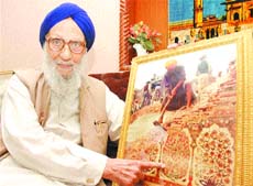 Giani Mohinder Singh shows the picture of Akal Takht being demolished in 1985 by Sikh radicals. It was on his intervention that the demolition of the original podium of the Takht was saved.