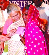 Delhi Chief Minister Sheila Dikshit speaks to a woman after giving her the Below Poverty Line (BPL) card during a function in the Capital on Friday. 