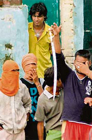 A youth, his face masked, brandishes a sword in Rajiv Colony, Panchkula