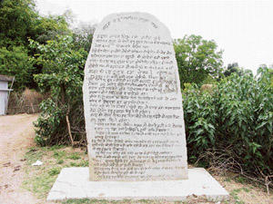 A stone at the entrance to a village in Jharkhand lists rules and regulations in Mundari, the local language