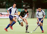 Pakistans Rehan Butt (centre) fights for the ball with a Japanese defender during their Asia Cup match in Chennai on Saturday.