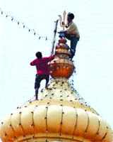 Workers putting up decorative lights at Birla Mandir.