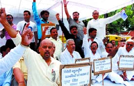 Traders under the banner of Confederation of All India Traders stage a dharna at Jantar Mantar, asking the government to stop entry of corporate retailers into retail trade, in the Capital on Sunday. 