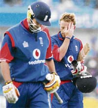 Paul Collingwood (R) and James Anderson leave the pitch as rain halts play and India are declared winners during the fifth one-day international between England and India at Headingley stadium in Leeds