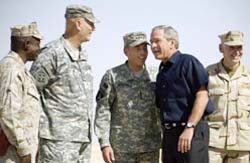 US President George W. Bush (second from right) speaks with General David Petraeus (centre) and others upon his arrival at Al-Asad Air Base in Anbar province in Iraq 