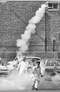A supporter of Nawaz Sharif throws a tear gas shell back at the police during a pro-Sharif rally in Rawalpindi on Monday.