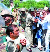 Police personnel take away BJP activists during their protest against sealing, demolition in unauthorised colonies near the Delhi Vidhan Sabha on Thursday