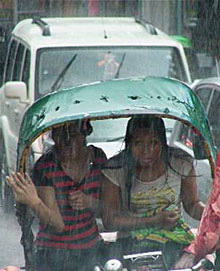 Two girls in a rickshaw during rain in Gurgaon on Thursday.