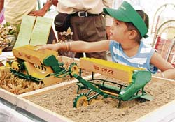 A child displays models of the latest farm equipment during the Kisan Mela in Ludhiana on Friday.