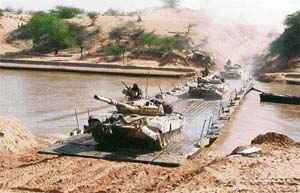 Peace-time exercises in the western sector: Tanks cross a bridge during an offensive in the desert