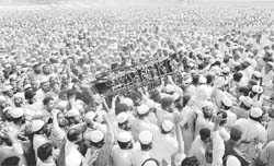 Thousands of supporters gather as the coffin of a slain pro-Taliban cleric is carried at a stadium in Peshawar