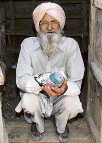 Baba Harbans Singh (95), the oldest pigeon fancier of Punjab, with a Pakistani pigeon at Narli village in Tarn Taran