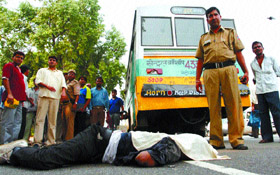 Police personnel and public stand near the body of Sachin who died in an accident near Rail Bhawan in the Capital on Thursday