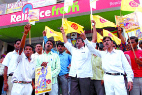 Activists of the traders group, Rashtriya Vyapar Mandal, shout slogans against Reliance Fresh store during the demonstration outside its outlet in Noida (UP) on Thursday