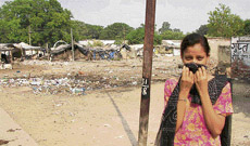 A girl covers her face as she passes through a garbage dump in Ambala.